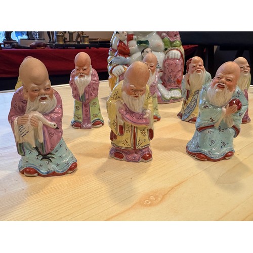 932 - A mid 20thC hand painted porcelain figure of a happy Buddha with five children measuring approx 20cm... 