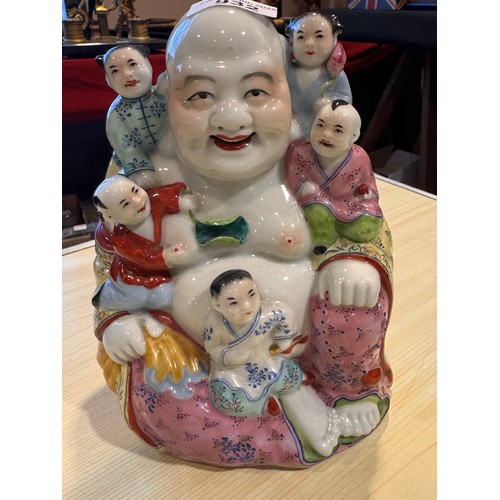 932 - A mid 20thC hand painted porcelain figure of a happy Buddha with five children measuring approx 20cm... 