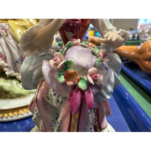 433 - A Sitzendorf lady with a flowered hat together with two Capodimonte figurines of lady with flowers a... 