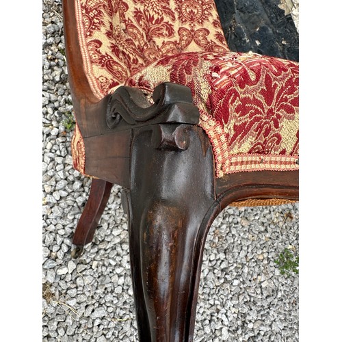 8 - A Victorian rosewood framed nursing chair with cabriole legs and brass castors. 94 h x 55 w x approx... 