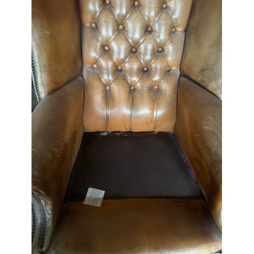 10 - A brown leather wing backed armchair. 80cm w x 106cm h to back.
