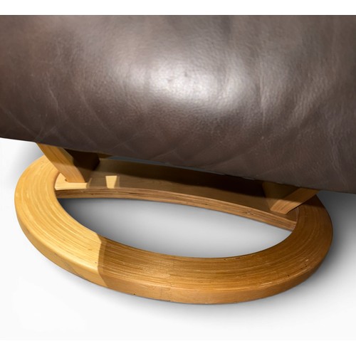 160 - A dark brown leather Stressless style reclining armchair and footstool.