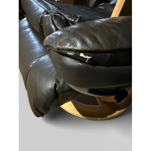 160 - A dark brown leather Stressless style reclining armchair and footstool.