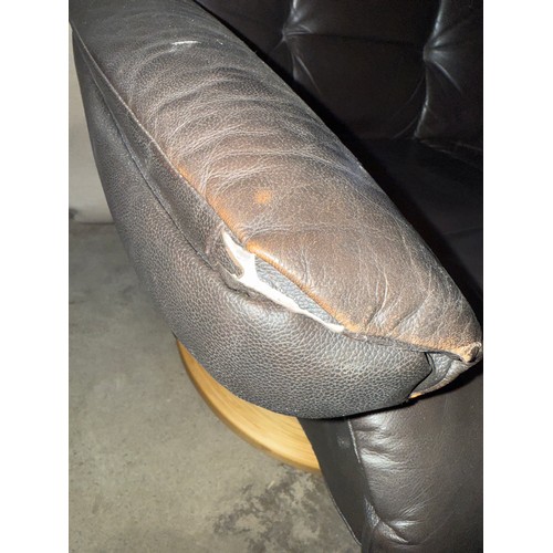 160 - A dark brown leather Stressless style reclining armchair and footstool.