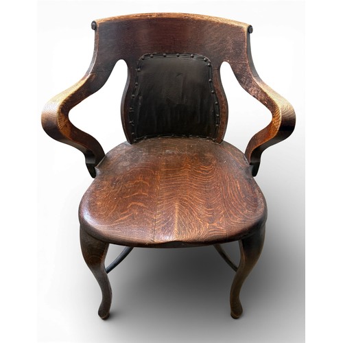 99 - An oak captains chair with cabriole legs and upholstered back.