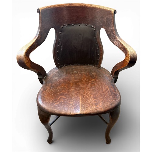 99 - An oak captains chair with cabriole legs and upholstered back.