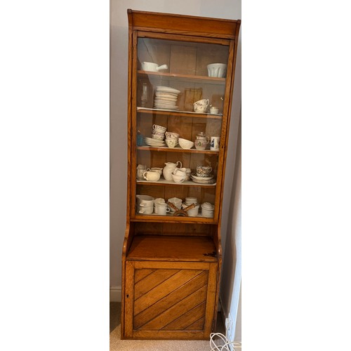 108 - An oak cabinet with glazed top and solid door to base. 203cm h x 63cm w x 36cm d.