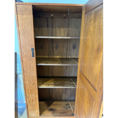 116 - An oak Arts and Craft style single door cupboard with shelving to the interior. 189cm h x 99cm w x 3... 