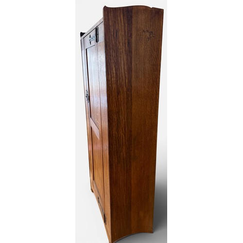 116 - An oak Arts and Craft style single door cupboard with shelving to the interior. 189cm h x 99cm w x 3... 