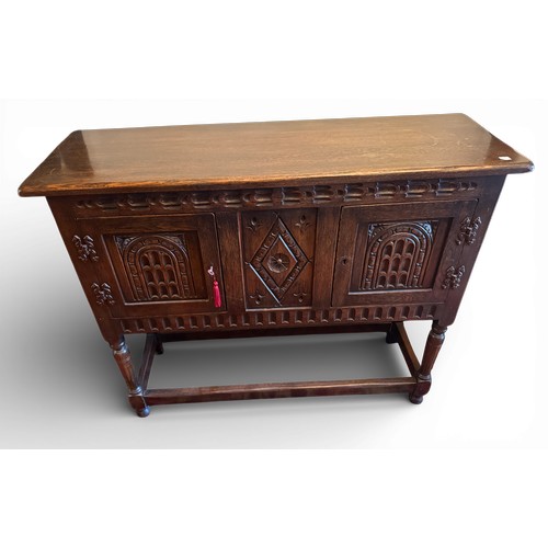 148 - An oak two door side cabinet with carving to front.