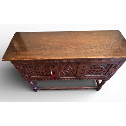 148 - An oak two door side cabinet with carving to front.