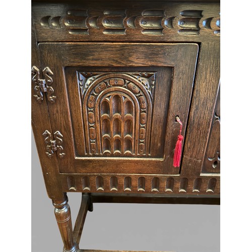 148 - An oak two door side cabinet with carving to front.