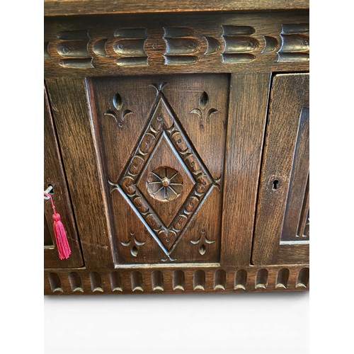 148 - An oak two door side cabinet with carving to front.