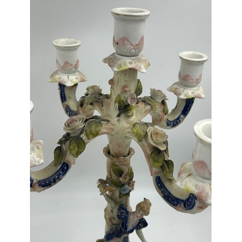 418 - A pair of ornate porcelain figural four branch candelabras in the Dresden style. 47cm h.