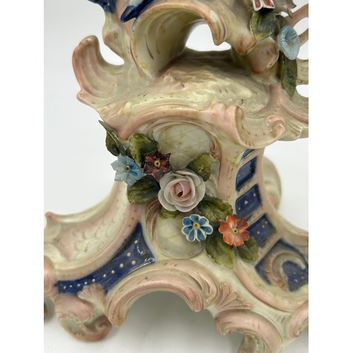 418 - A pair of ornate porcelain figural four branch candelabras in the Dresden style. 47cm h.