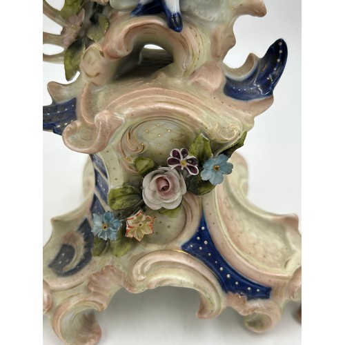 418 - A pair of ornate porcelain figural four branch candelabras in the Dresden style. 47cm h.