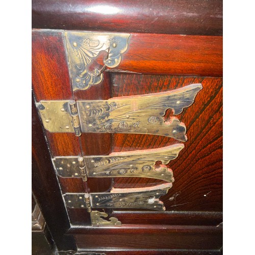 125 - An oriental cabinet with two shelves and two drawers over cupboard with brass fittings. 50cm w x 33c... 