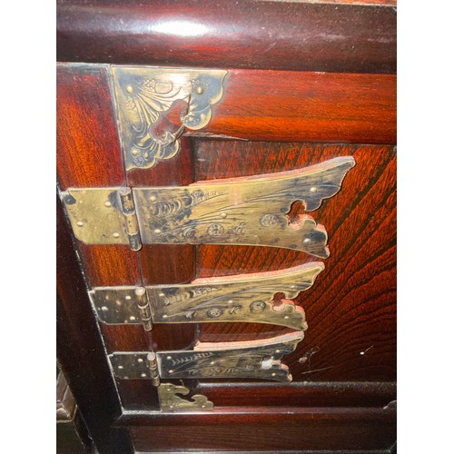 125 - An oriental cabinet with two shelves and two drawers over cupboard with brass fittings. 50cm w x 33c... 