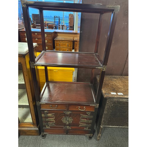 125 - An oriental cabinet with two shelves and two drawers over cupboard with brass fittings. 50cm w x 33c... 