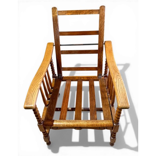 22 - Oak framed armchair, 63.5cm w arm to arm and matching footstool with bobbin turnings.