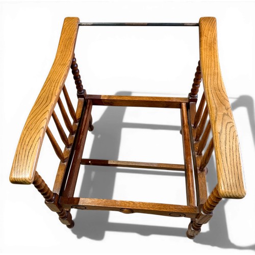 22 - Oak framed armchair, 63.5cm w arm to arm and matching footstool with bobbin turnings.