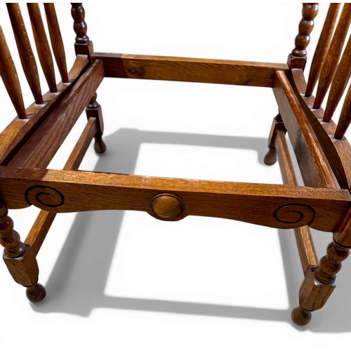 22 - Oak framed armchair, 63.5cm w arm to arm and matching footstool with bobbin turnings.