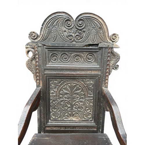 43 - A 17thC carved oak wainscot armchair with high back rest, down swept arm rests, carving to the top a... 
