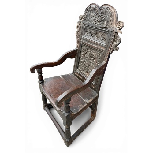 43 - A 17thC carved oak wainscot armchair with high back rest, down swept arm rests, carving to the top a... 