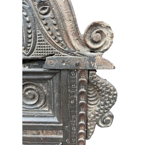 43 - A 17thC carved oak wainscot armchair with high back rest, down swept arm rests, carving to the top a... 