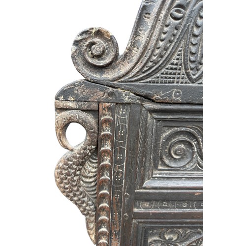 43 - A 17thC carved oak wainscot armchair with high back rest, down swept arm rests, carving to the top a... 