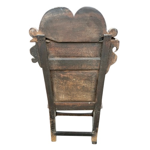 43 - A 17thC carved oak wainscot armchair with high back rest, down swept arm rests, carving to the top a... 