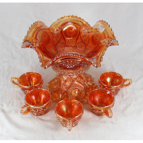 77 - An amber coloured Carnival glass punch bowl on stand, together with five cups