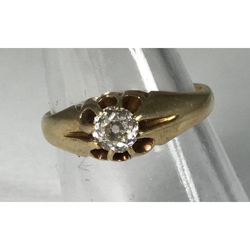 106 - A yellow metal (tests as 14ct gold or above) gents ring, the top centrally claw set with a round, tr... 