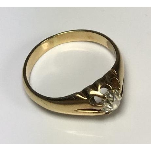 106 - A yellow metal (tests as 14ct gold or above) gents ring, the top centrally claw set with a round, tr... 