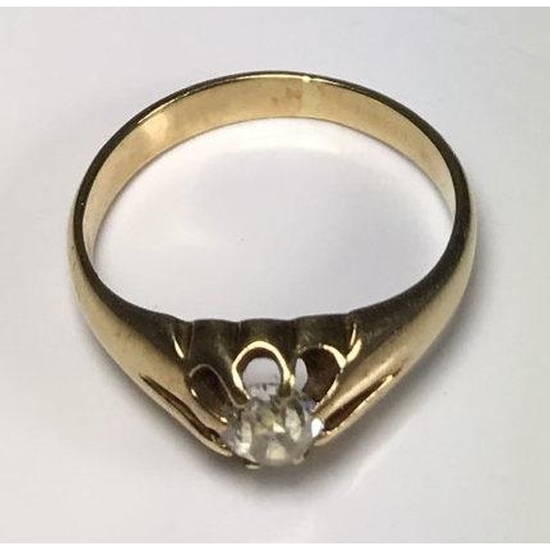 106 - A yellow metal (tests as 14ct gold or above) gents ring, the top centrally claw set with a round, tr... 