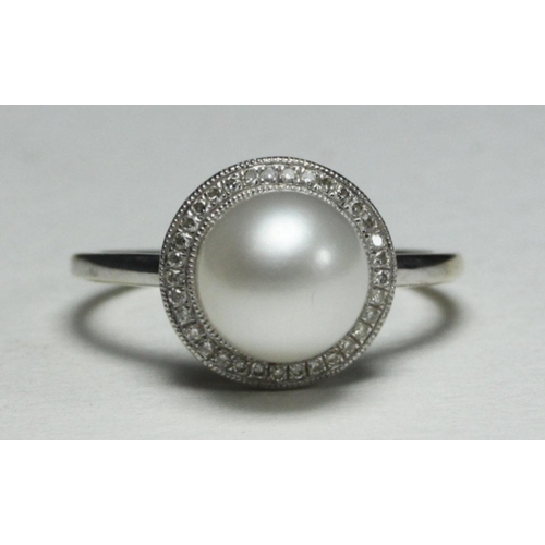 110 - WITHDRAWN  A 9k white gold ring centrally-set with a single pearl surrounded by 33 small diamonds, 2... 