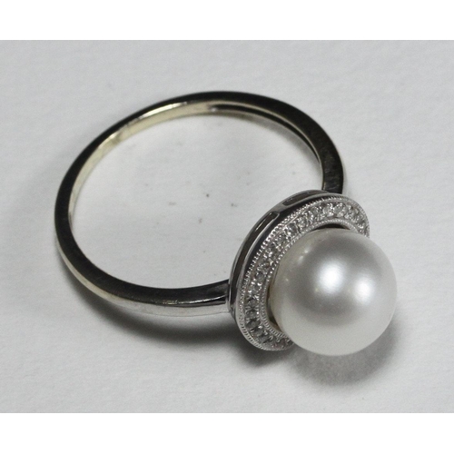 110 - WITHDRAWN  A 9k white gold ring centrally-set with a single pearl surrounded by 33 small diamonds, 2... 