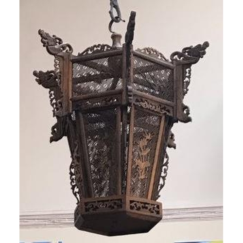 58 - An Oriental intricately carved wooden hanging bird cage, with dragon finials, lattice sides with app... 