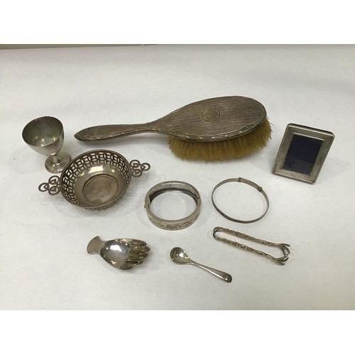 115 - A small collection of assorted silver items comprising a silver caddy spoon in the form of a right h... 