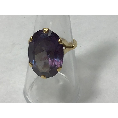 193 - An 18ct gold ring claw set with an oval amethyst coloured stone measuring 2x1.5cm, gross weight 8.2g... 