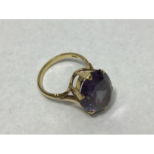 193 - An 18ct gold ring claw set with an oval amethyst coloured stone measuring 2x1.5cm, gross weight 8.2g... 