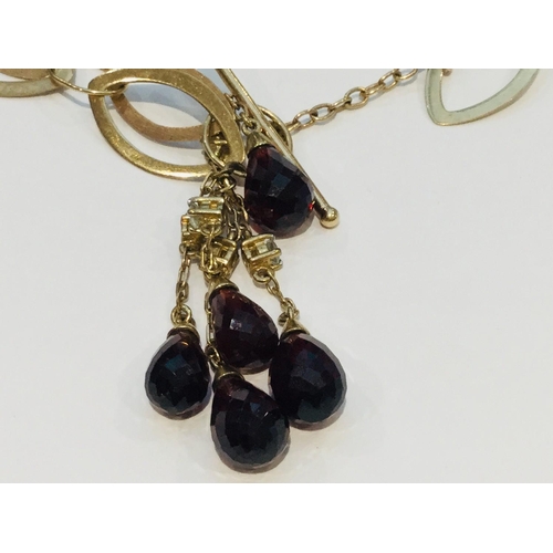 198 - A 9ct gold interlinking design necklace with 5 x briolette cut garnets on a bar link fastening, weig... 