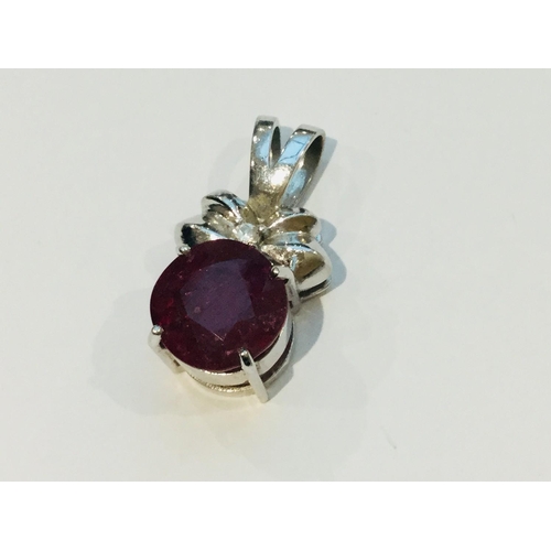 200 - An 18ct white gold pendant set with a large Ruby, measuring 13mm, and a small round diamond to the c... 