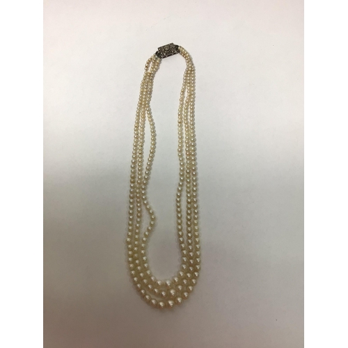 211 - A three row pearl necklace of graduated cultured pearls with a silver clasp, 39cm including clasp