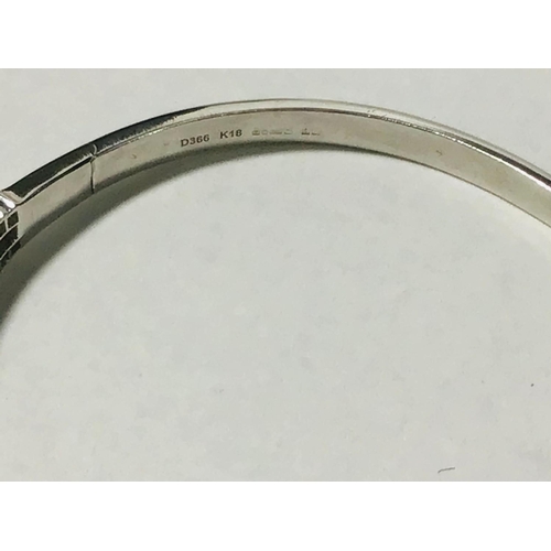 222 - A ladies 18ct white gold triple diamond set bangle. To the centre is set a graduated row of tapered ... 