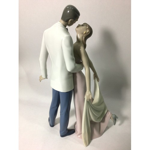 43 - A Lladro porcelain figure group of a finely dressed couple leaning in for a kiss, ‘Happy Anniversary... 