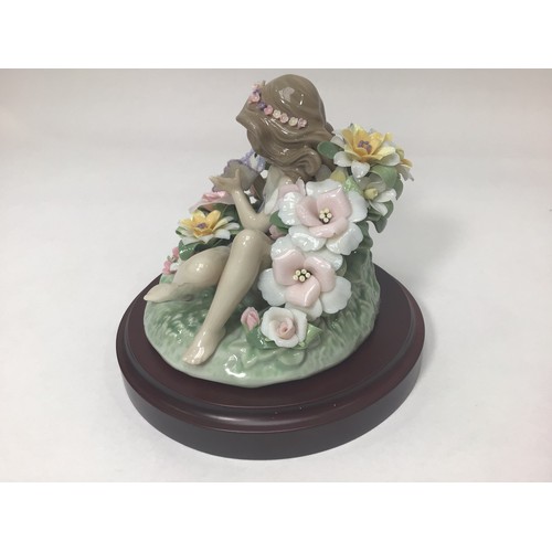 48 - A Lladro porcelain figure of a recumbent sprite amongst flowers holding a butterfly, ‘Sprite No. 172... 