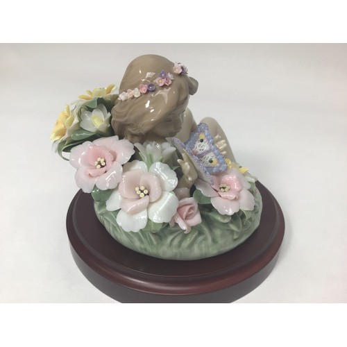 48 - A Lladro porcelain figure of a recumbent sprite amongst flowers holding a butterfly, ‘Sprite No. 172... 