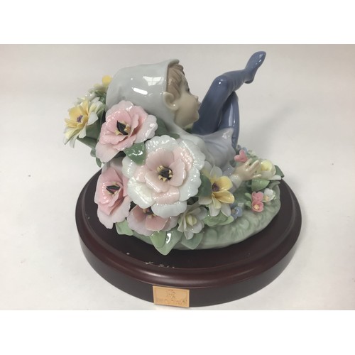 49 - A Lladro porcelain figure of a recumbent leprechaun amongst flowers, ‘Leprechaun No. 1721’, designed... 