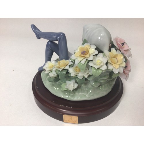 49 - A Lladro porcelain figure of a recumbent leprechaun amongst flowers, ‘Leprechaun No. 1721’, designed... 